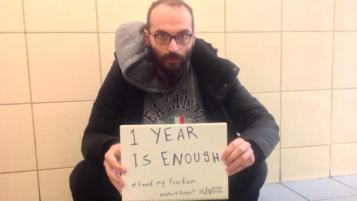 Fadi Mansour, en la terminal de Estambul, con un cartel reivindicativo.