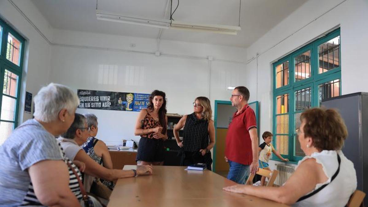 Laura Lara, Mar Herrera y Santiago Camporro, de pie, hablan con vecinas de Teatinos sobre el mural.