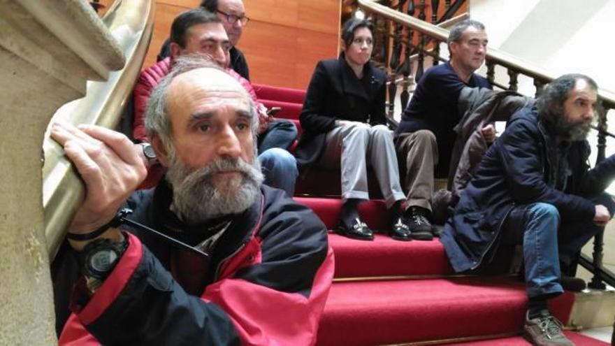 Extrabajadores de Naval Gijón se encadenan en las escalinatas del Ayuntamiento