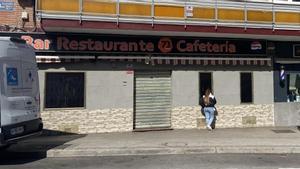 Una chica mira hacia el interior de la cafetería, que tiene las puertas cerradas pero gente dentro