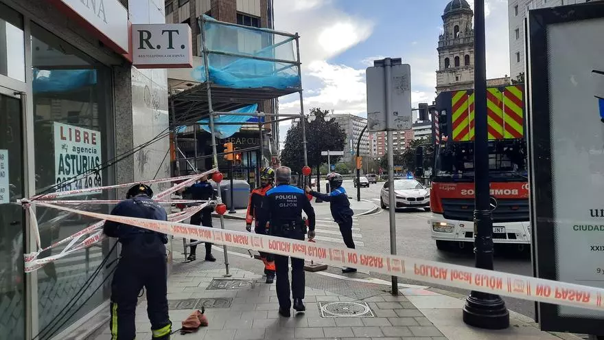 La Policía Local de Gijón, sujetando un andamio por el fuerte viento