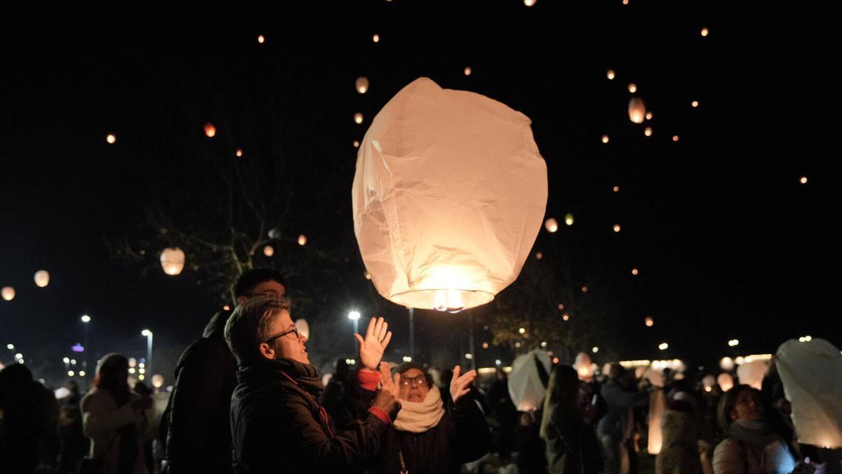 Una familia lanza un farolillo durante la Noche de los Deseos de 2024 en Badajoz
