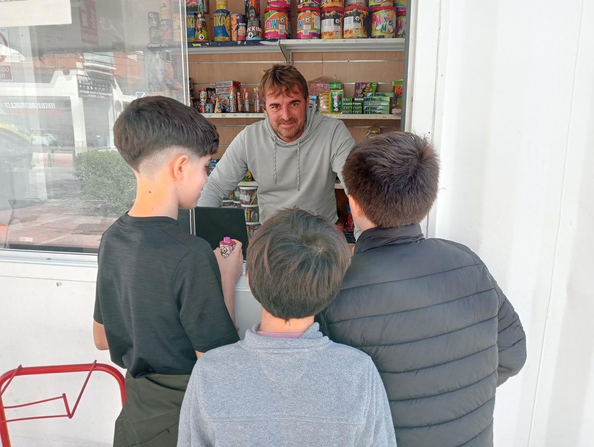 Pepe Borredà atiende a unos niños en su quiosco pirotécnico de Gandia