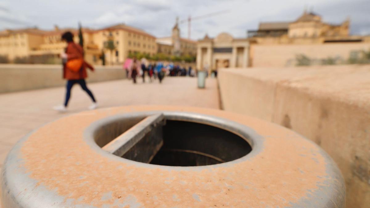 Una papelera cubierta de lodo, en el Puente Romano.