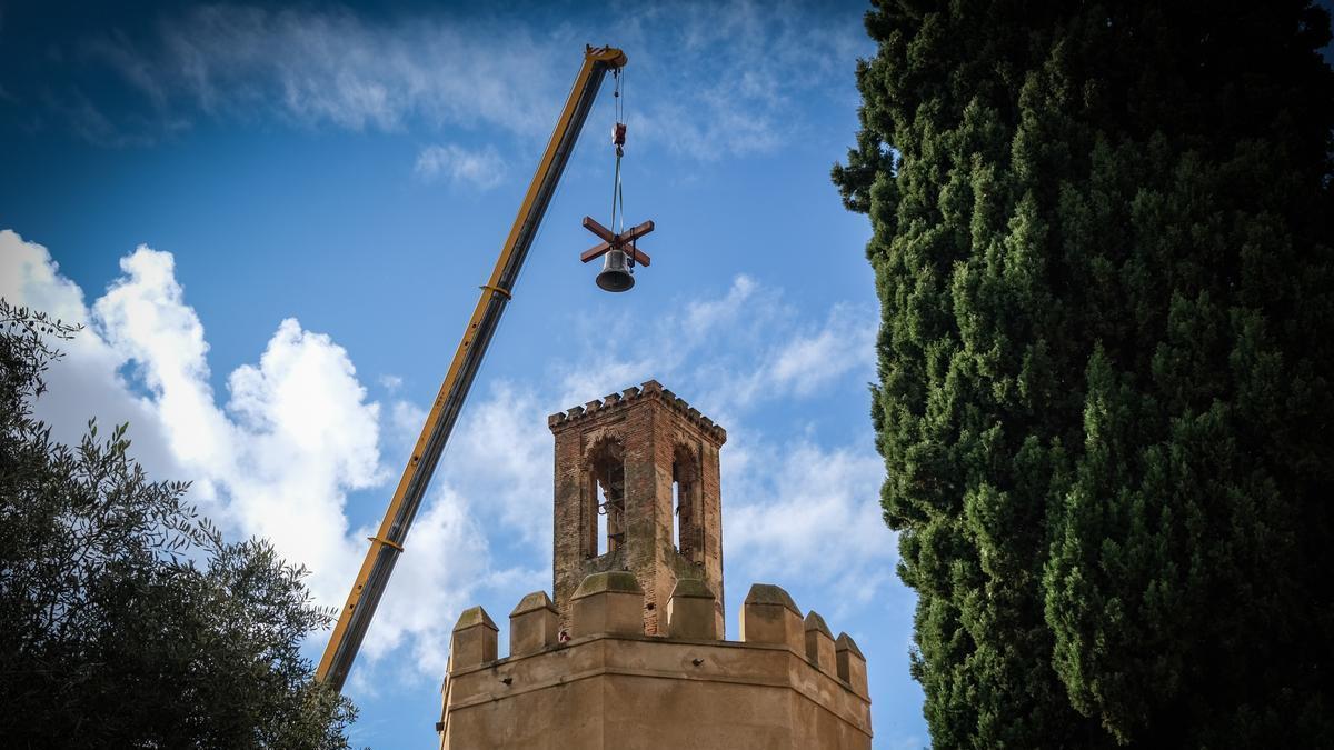 La grúa traslada la campana a la espadaña de la torre de Espantaperros.