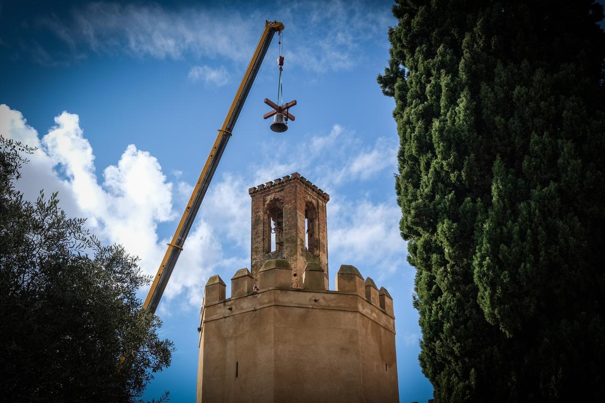 La grúa traslada la campana a la espadaña de la torre de Espantaperros.