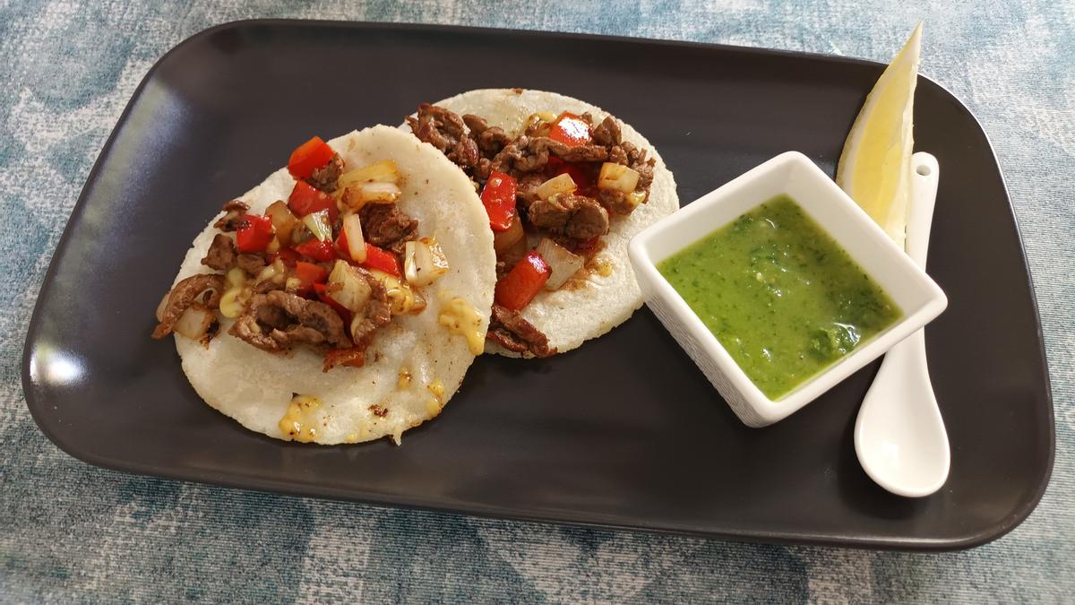 Heiß und saftig: Zwei selbst gemachte Tacos mit Rindfleisch, Zwiebeln und Paprika. Dazu scharfe Soße.