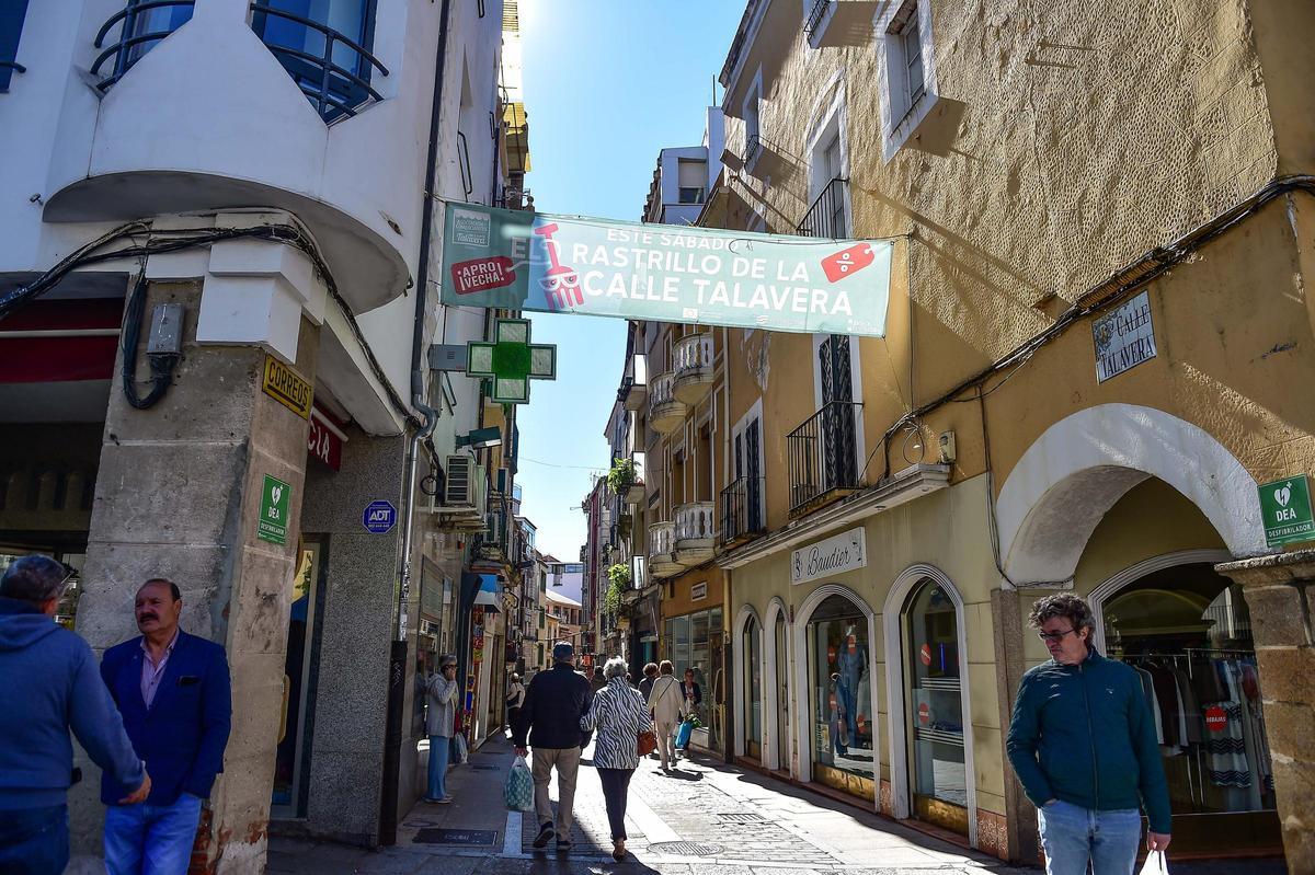 Un acceso a la calle Talavera de Plasencia, ya con la pancarta del rastrillo.
