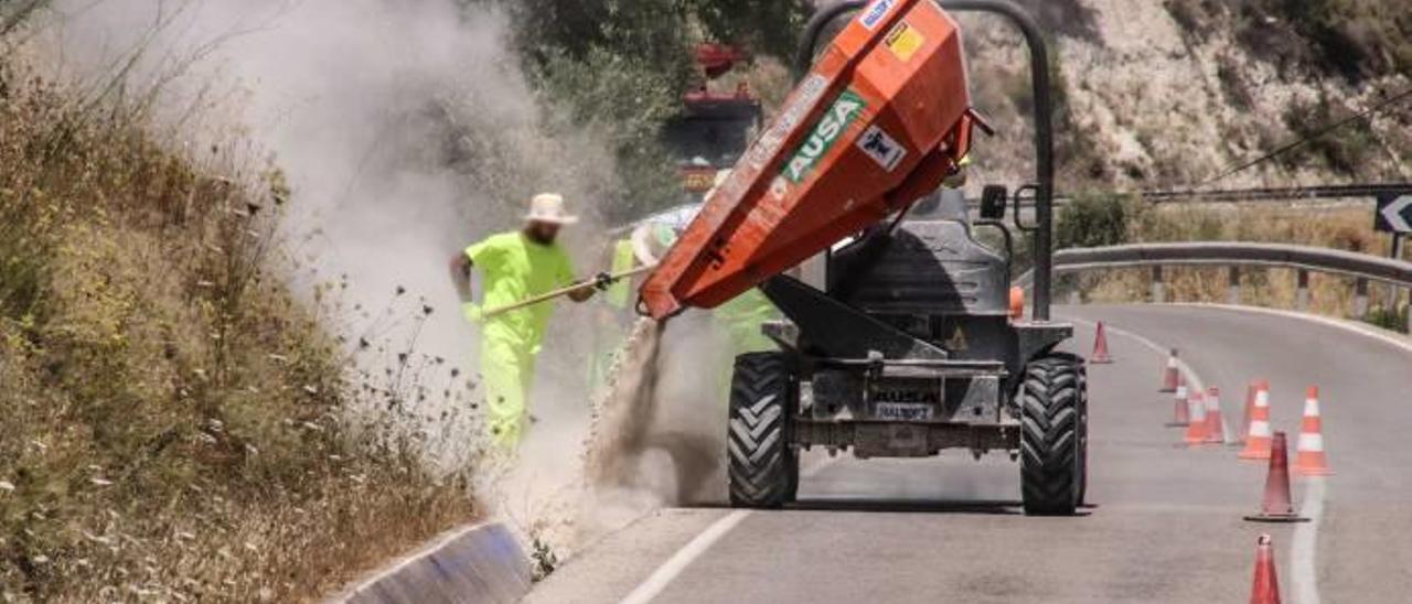 Operarios trabajando ayer en el rellenado de los canales de evacuación de aguas pluviales situados en la carretera Cocentaina-Benilloba.