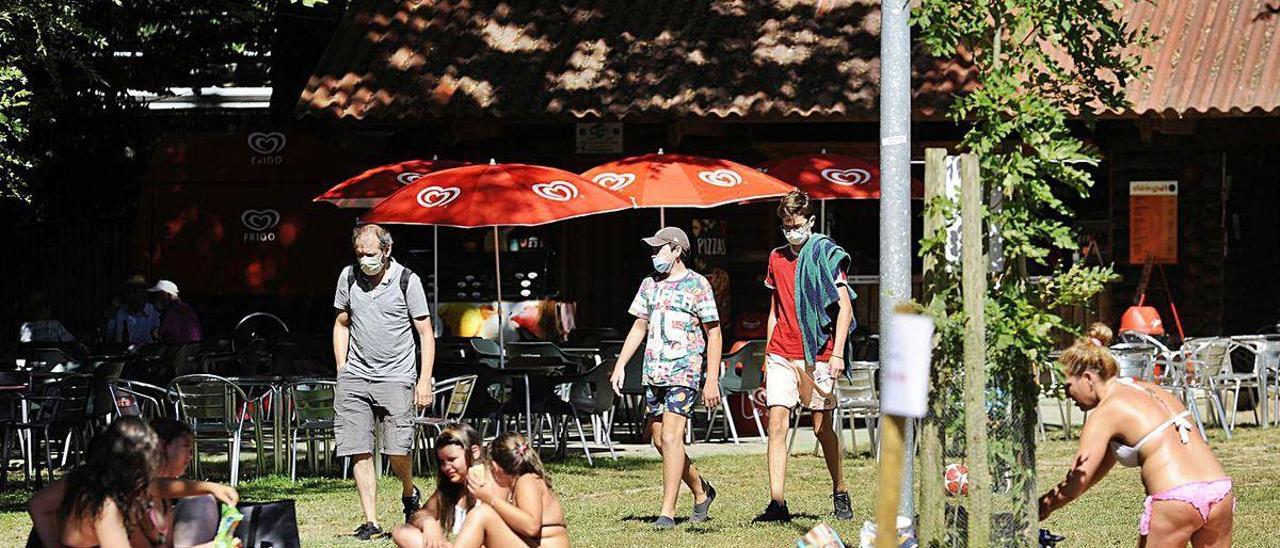 Gente disfruta del calor en la Área Recreativa de Merza, con uso de mascarilla obligatorio.