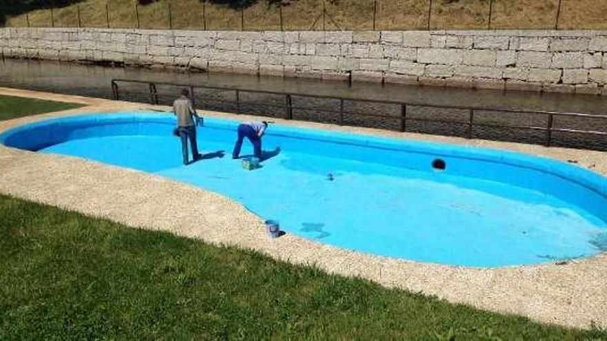 Los operarios municipales acondicionan la playa fluvial.