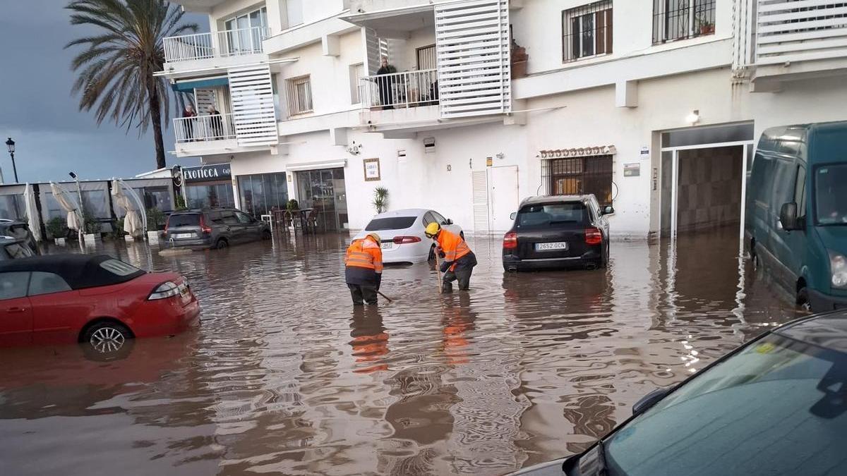 Operarios, el martes, achicando el agua que dejó un temporal en una urbanización de San Pedro.