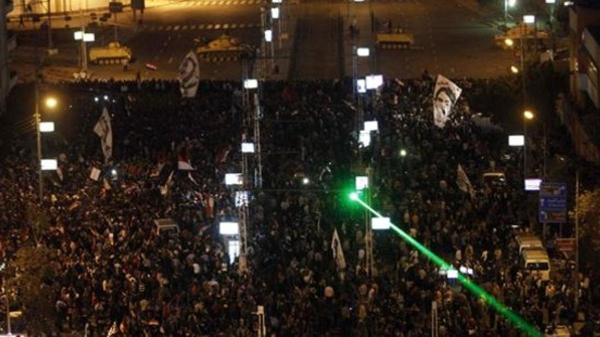 Manifestantes anti-Mursi se concentran ante el Palacio Presidencial, protegido aún por alambradas.