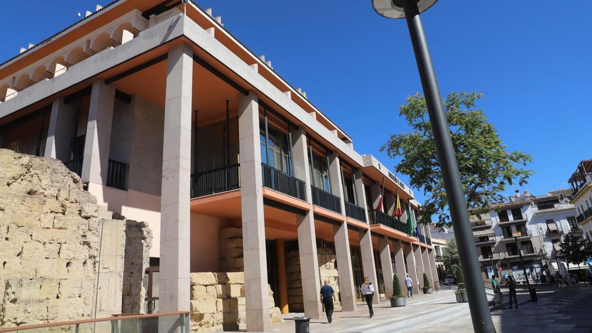 Varias personas caminan junto a la fachada del Ayuntamiento de Córdoba.