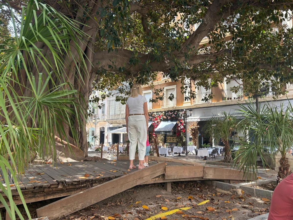 Uan turista juega con su hija en el puente del a plaza Gabriel Miró de Alicante.