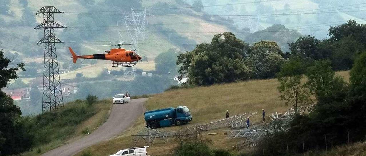 Trabajos de reparación de los tendidos en Lena, con un helicóptero de Red Eléctrica transportando las torres.