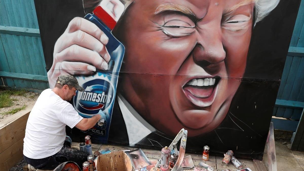 Un pintor de murales dibuja a Trump con una botella de desinfectante.
