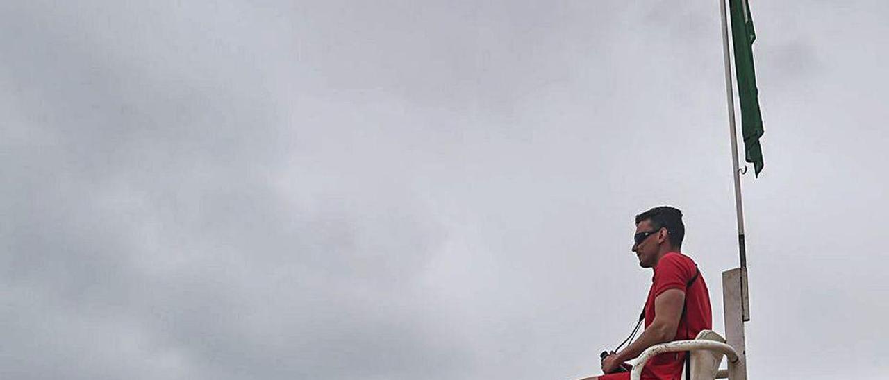 Socorristas en la playa de San Lorenzo, en Gijón, con las pequeñas torres de vigilancia que se instalaron ayer.