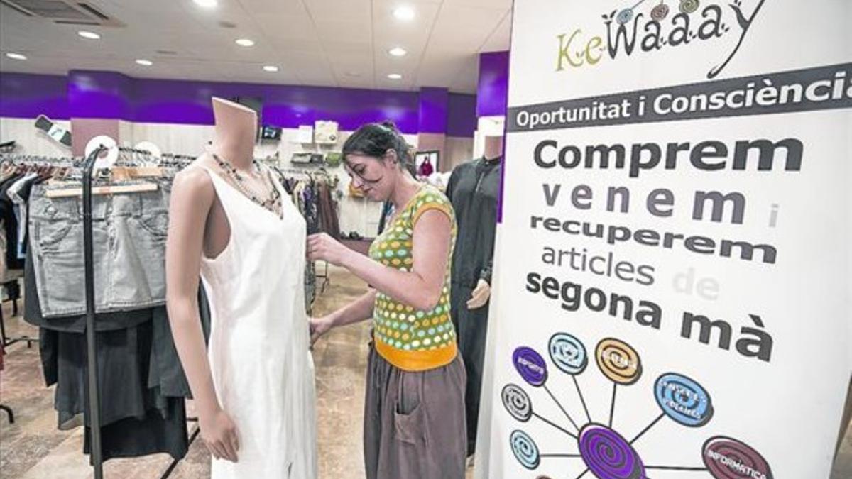 COMPRA BARATA Una joven mira la ropa de segunda mano de marca que vende Kewaaay en el Eixample.