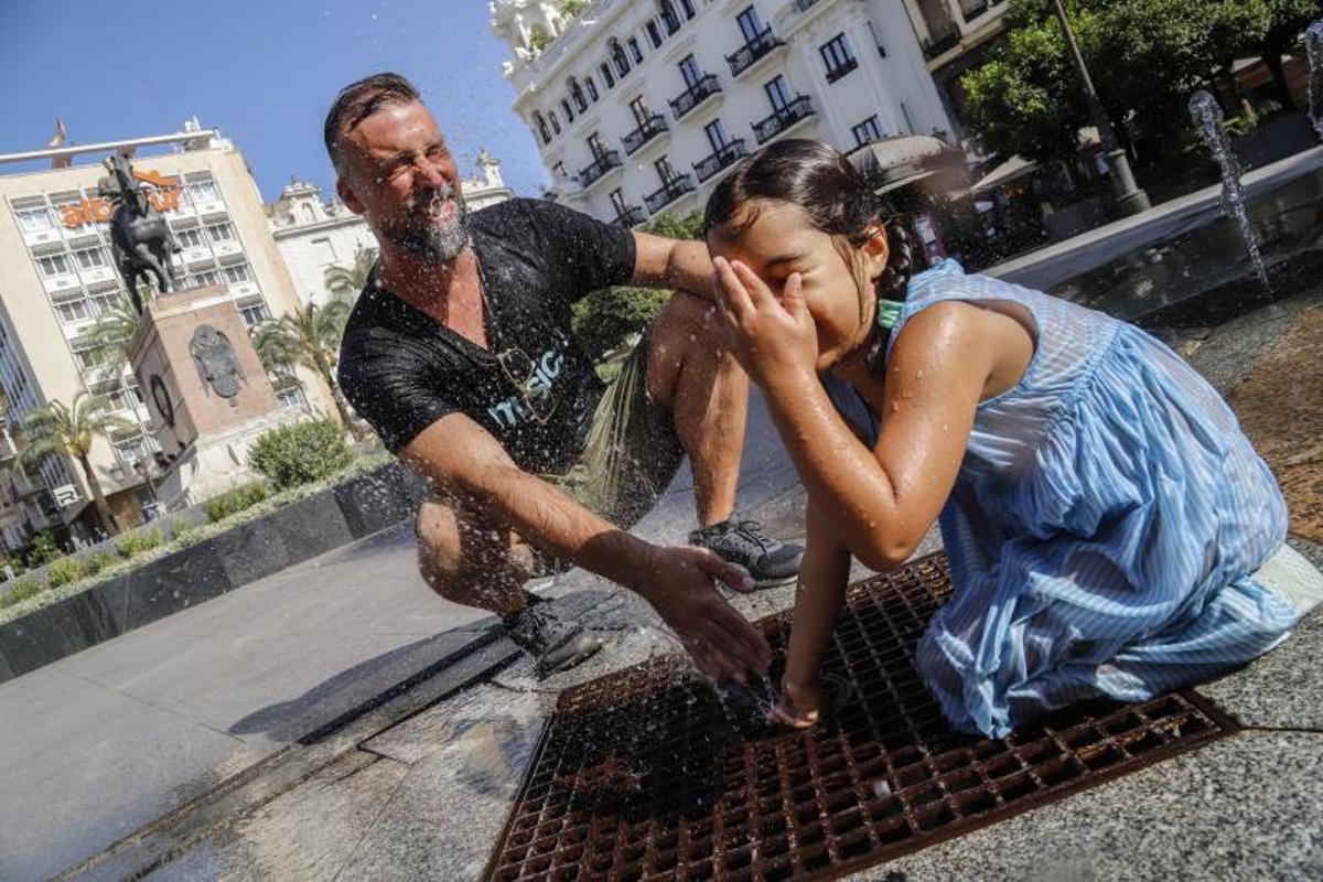 Unos turistas se refrescan frente al intenso calor durante el verano pasado en Córdoba.