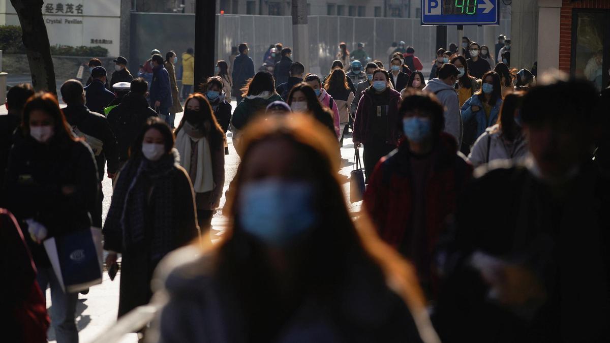 People wearing protective masks walk on a street, following new cases of the coronavirus disease (COVID-19), in Shanghai