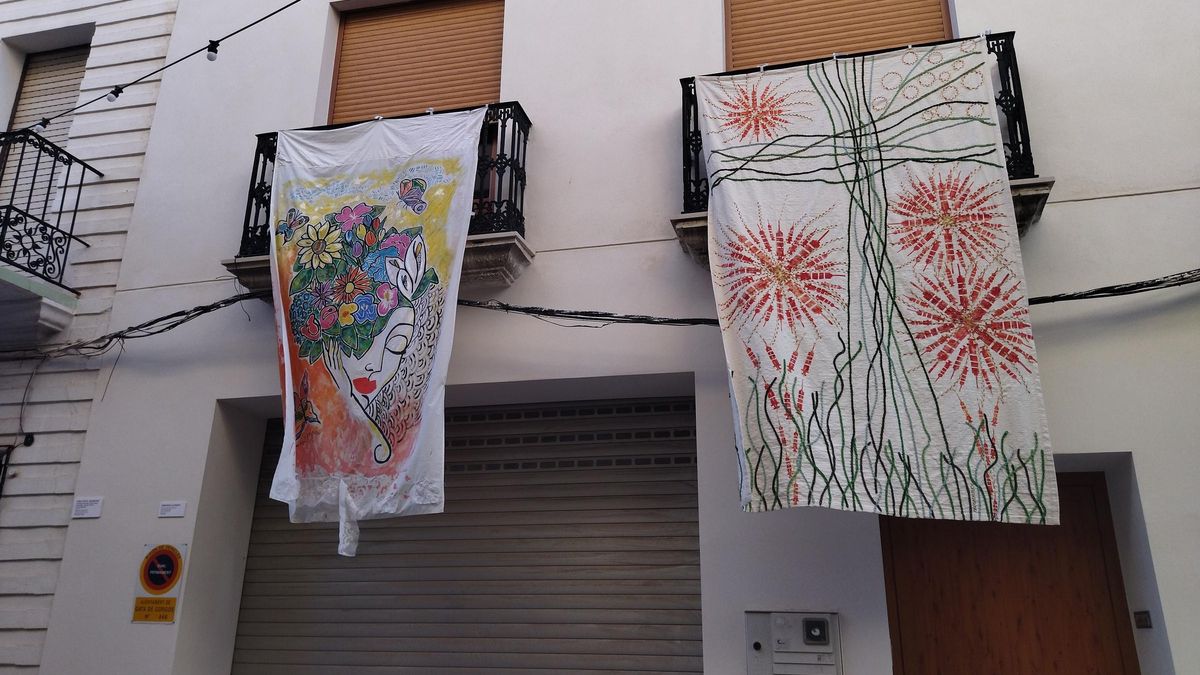 Telas colgadas de dos balcones de la calle Duquessa d'Almodóvar