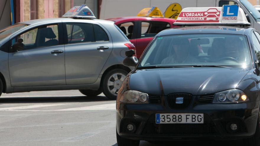 Un coche de autoescuela circula por las calles de la ciudad de Alicante.