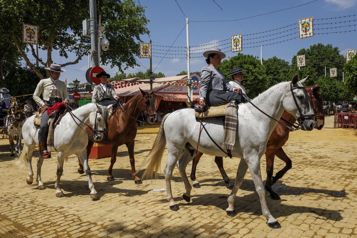 Caballistas durante el paseo de caballos con temperaturas primaverales por las calle del Real de la Feria.