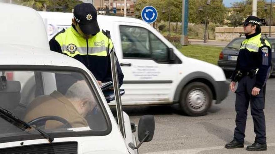 Un agente de la Policía Local imponiendo una multa al conductor de un vehículo.