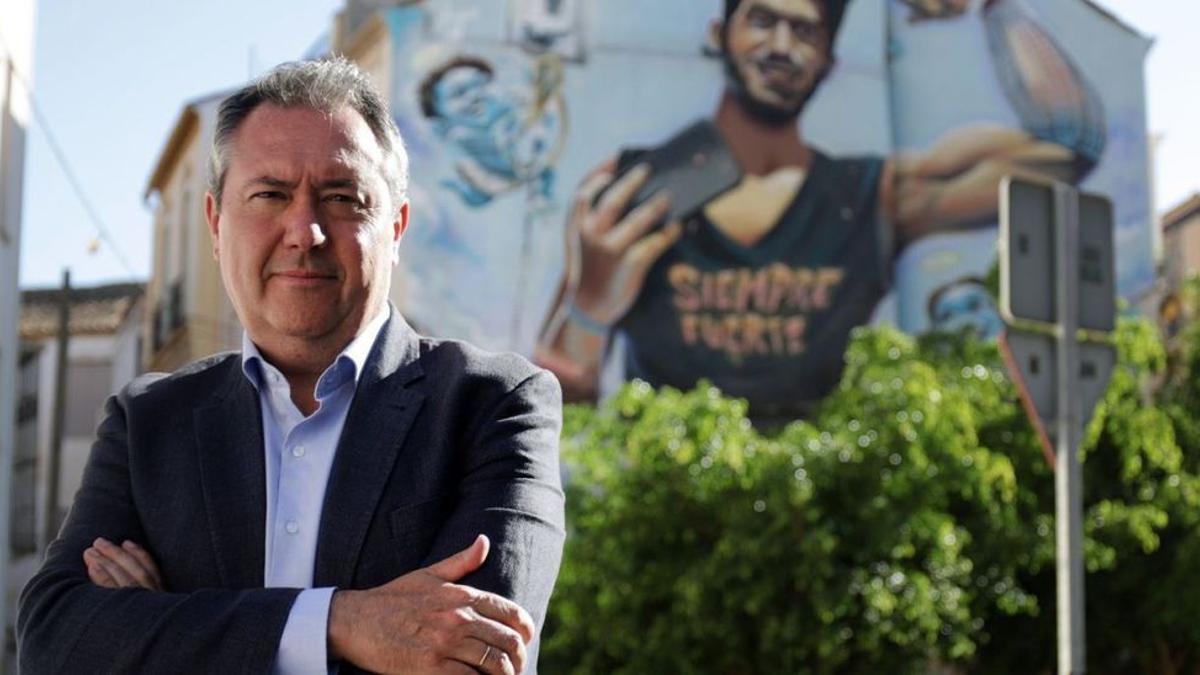 El candidato del PSOE, Juan Espadas, junto al grafiti que recuerda a Pablo Ráez en el barrio malagueño de Lagunillas.