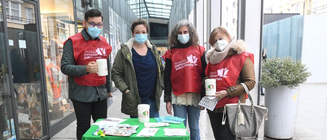 Mila Oreiro, directora de Párkinson Galicia-A Coruña, con un grupo de voluntarios, en una mesa informativa, ayer, en la plaza de Lugo.  | // C. PARDELLAS