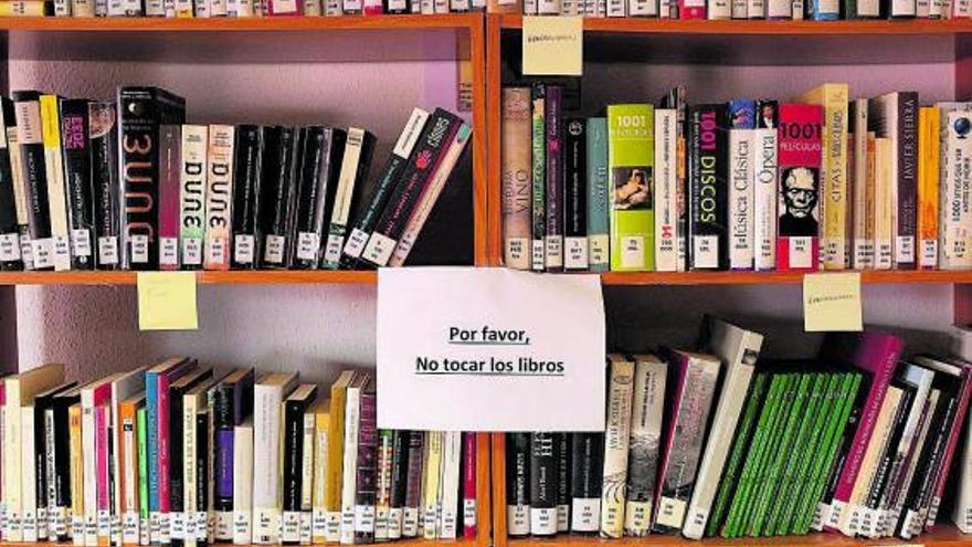 Un cartel pide a los usuarios no tocar los libros como medida de prevención. | Emilio Fraile