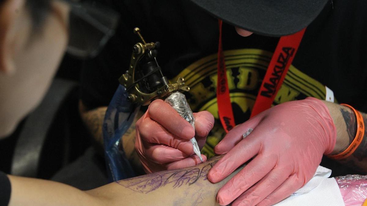 Un tatuador realizando un tatuaje