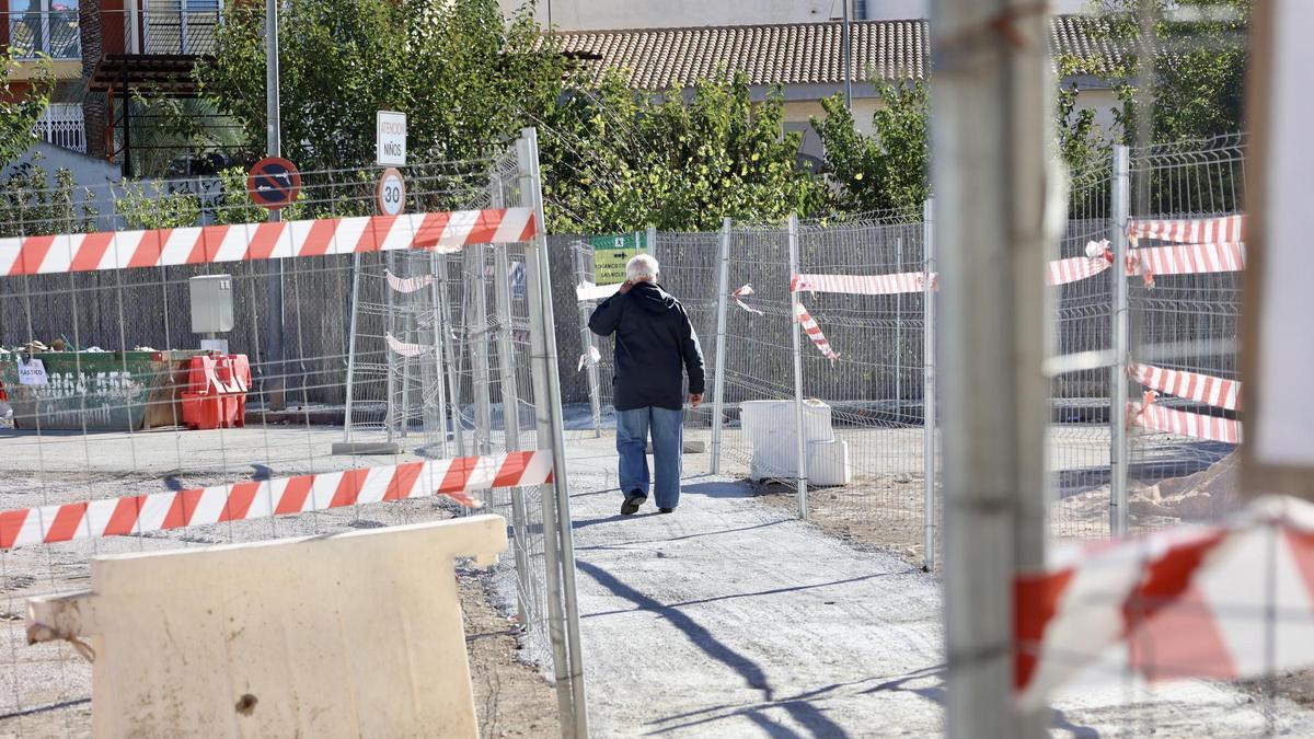 Un hombre atraviesa las vallas  perimetrales instaladas junto al centro municipal por las obras del soterramiento.