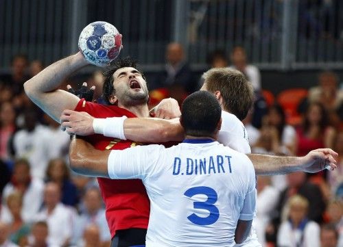 Spain's Joan Canellas Reixach is challenged by France's Didier Dinart in their men's handball quarterfinals match at the Basketball Arena in London
