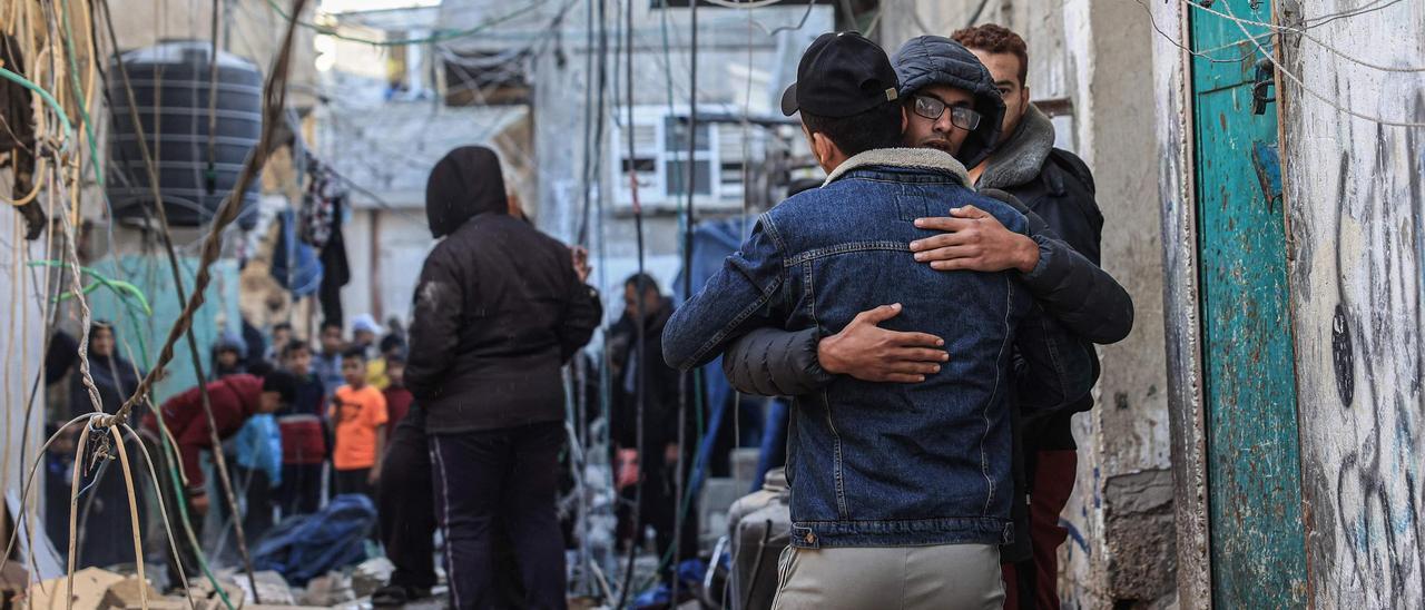 Palestinos abrazándose después de un ataque del ejército israelí en Raffah.
