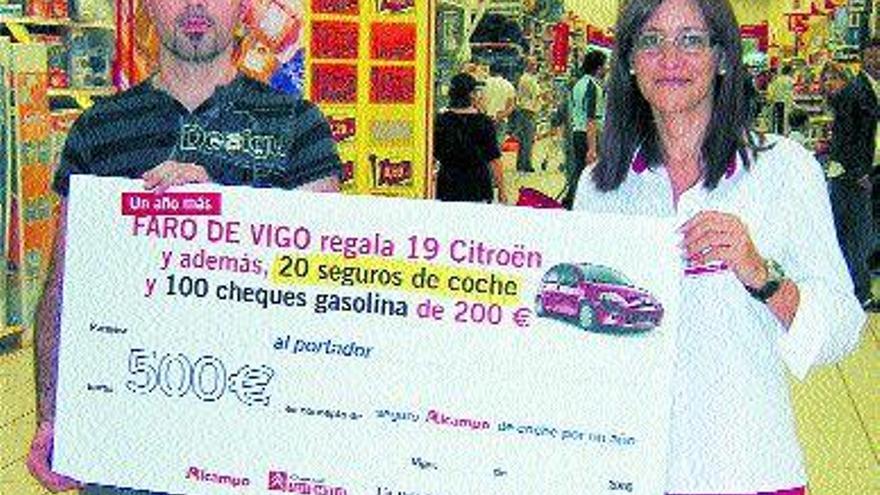 Francisco Javier Aldín recibe el seguro de 500 euros de manos de Patricia Alonso, coordinadora de Cajas en Alcampo 2.