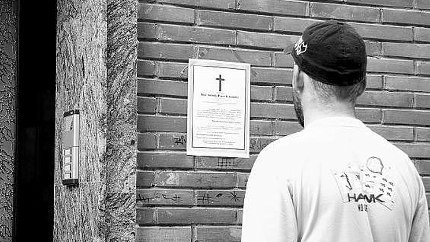 Un vecino, ayer, leyendo la esquela de José Antonio Pérez colocada en el portal donde vivía la víctima.