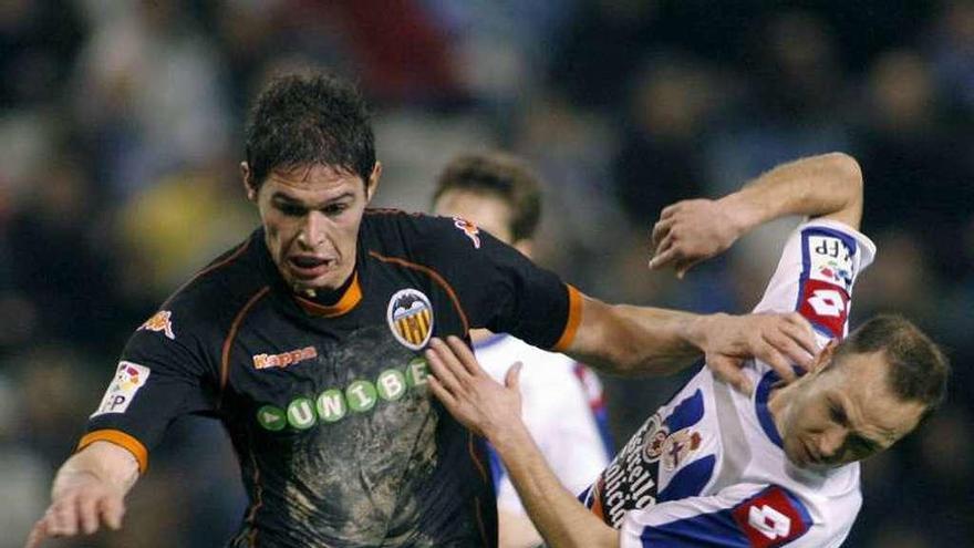 Laure pugna con Zigic frente al Valencia en enero de 2010.