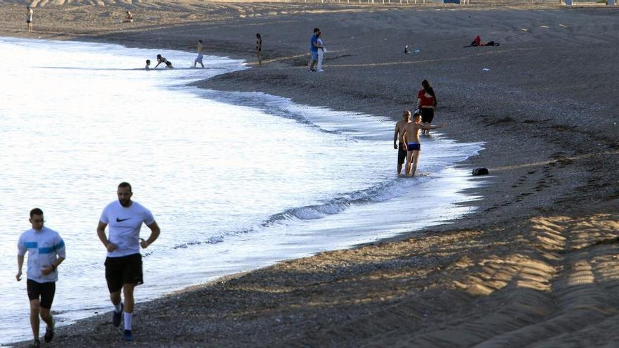 Gente haciendo deporte y paseando en la playa de la Malagueta.