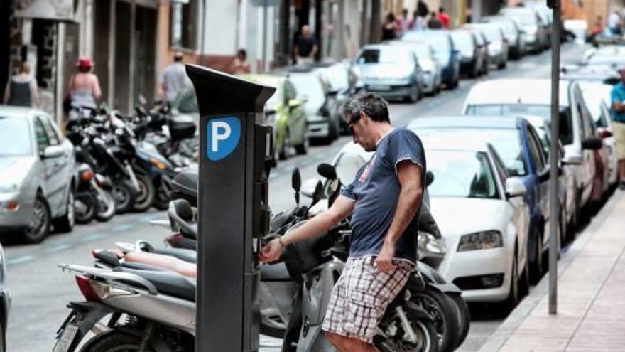 Un vecino paga la zona azul tras estacionar su vehículo en una calle del centro de Benidorm.