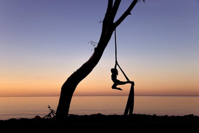 Una persona realiza acrobacias al amanecer en los Baños del Carmen en Málaga.
