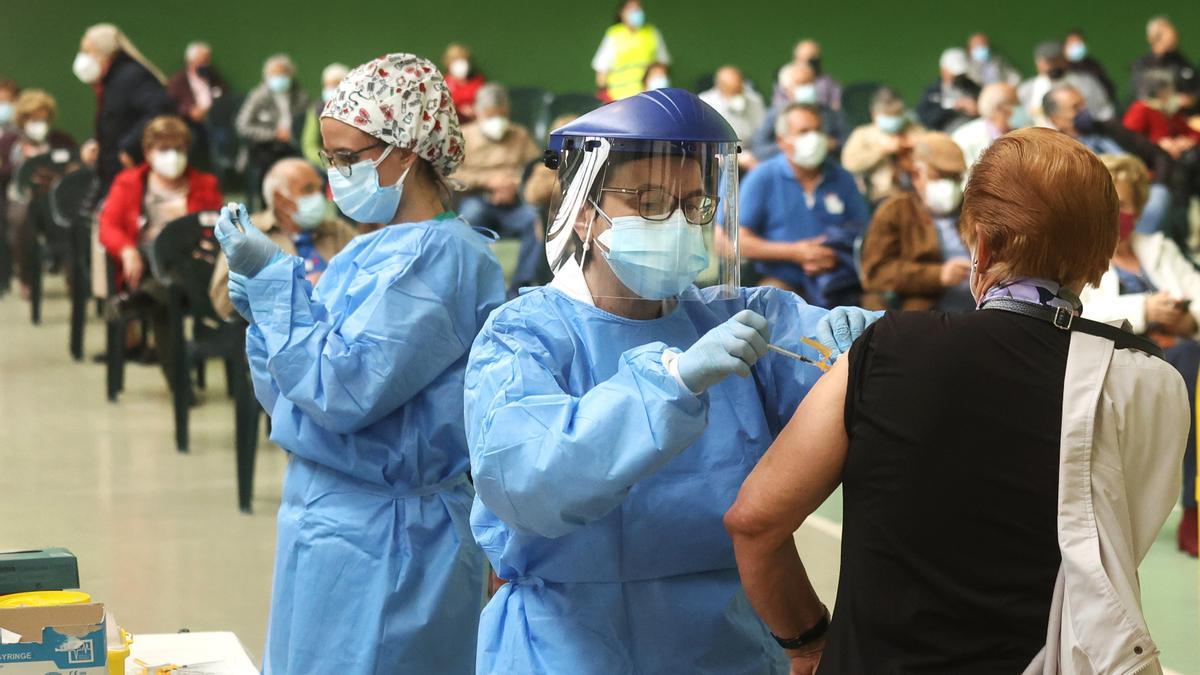 Una mujer recibe una vacuna frente al COVID.