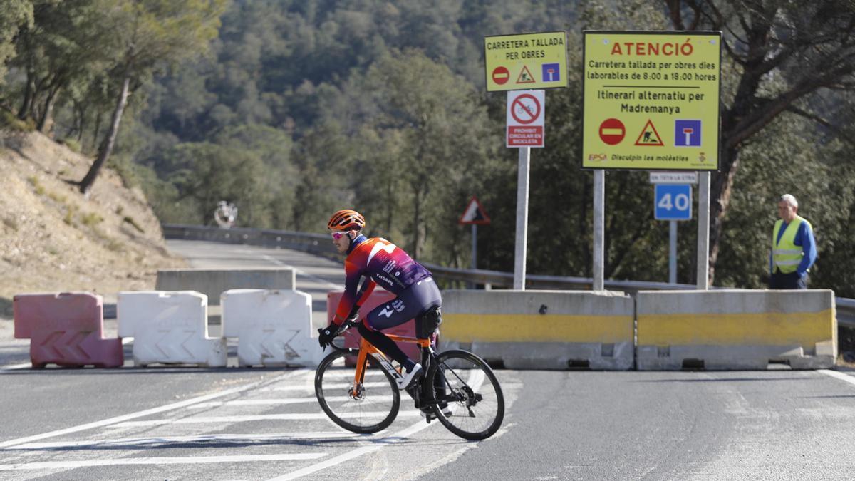 Un ciclista fa mitja volta en trobar la carretera de pujada als Àngels tallada.