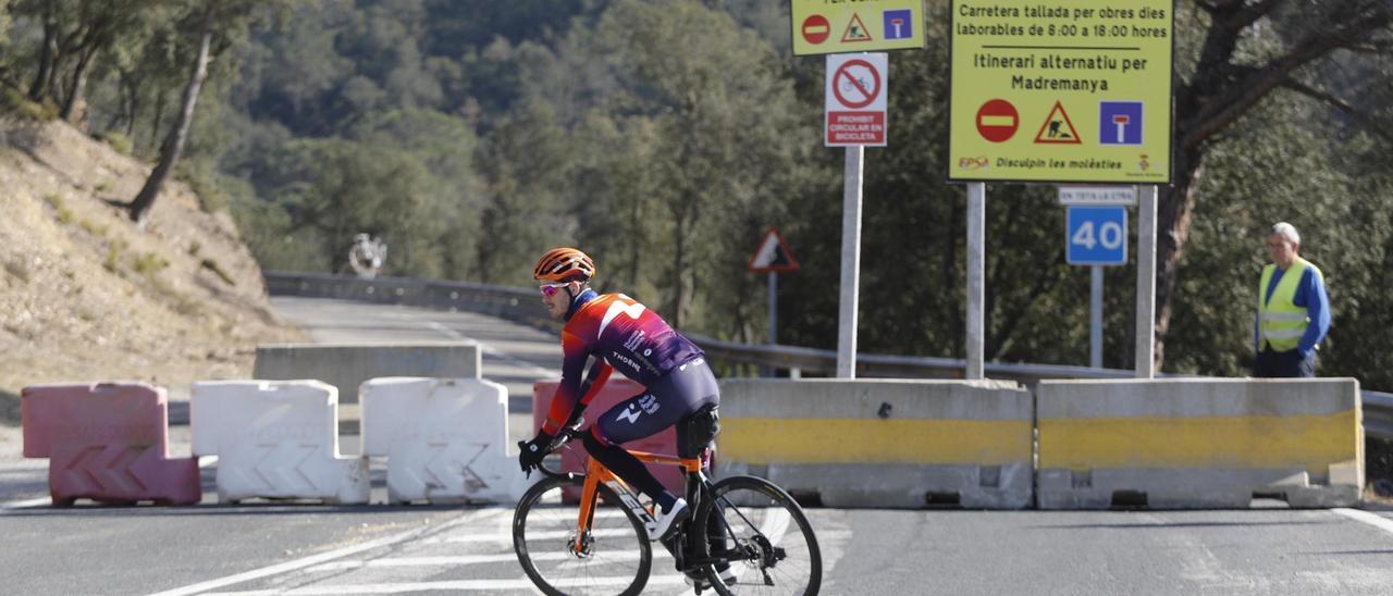 Un ciclista fa mitja volta en trobar la carretera de pujada als Àngels tallada.