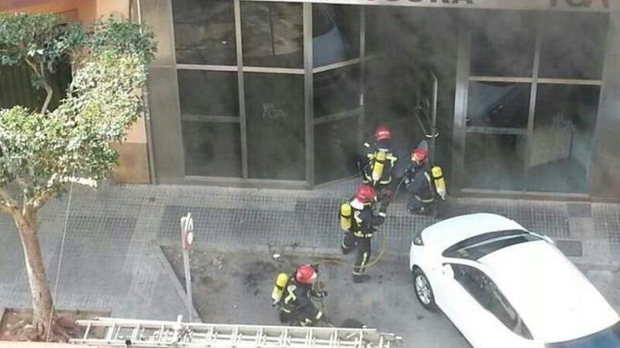 Los bomberos acceden a la sucursal de Almassora entre el humo.