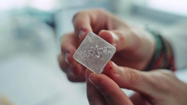 Un dispositiu antidroga amb forma de glaçó de gel, dissenyat per detectar substàncies utilitzades en casos de submissió química a l’introduir-lo en una beguda. Si detecta estupefaents, el líquid canvia de color i es converteix en una gelatina que n’impedeix el consum.