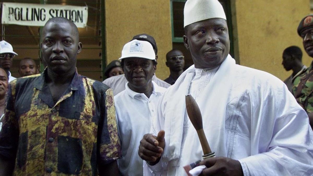 El expresidente de Gambia Yahya Jammeh (izquierda), con su vara de mando y su ejemplar del Corán.