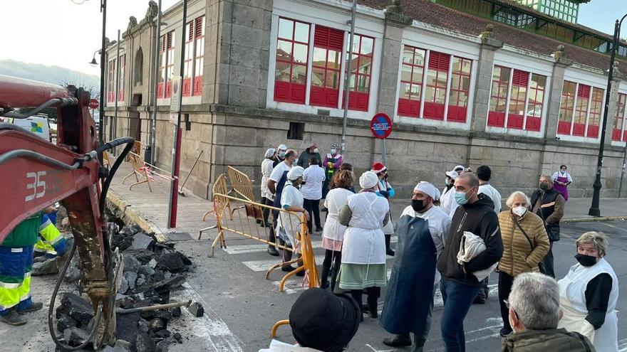 Un grupo de vendedores, instando a los operarios a parar la obra y reabrir el tramo de calle, esta mañana