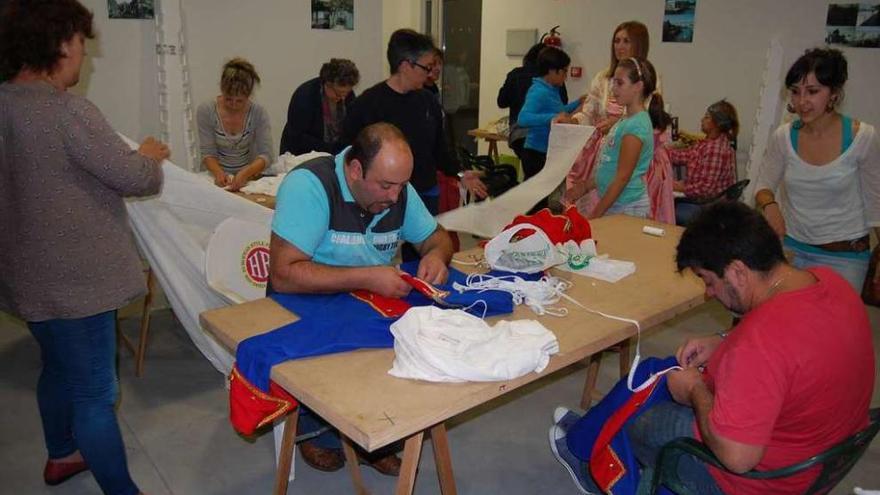 Los vecinos trabajan en la confección de los trajes de época, ayer, en el local de Rande. // Faro